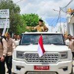 Presiden Prabowo Subianto saat menyapa masyarakat dari atas kendaraan Maung, di Kupang, NTT